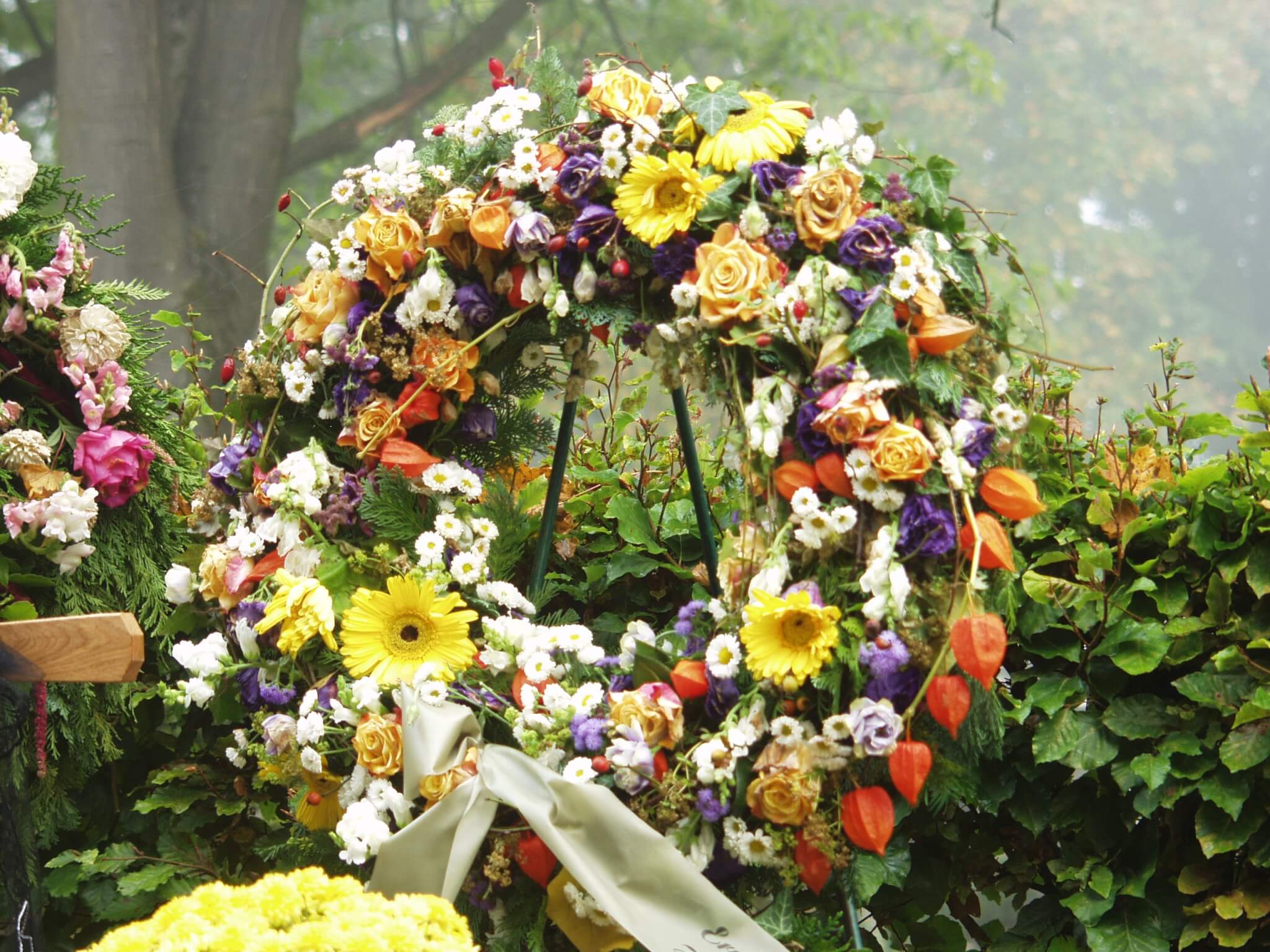 Trauerkranz mit gelben und orangefarbenen Blüten