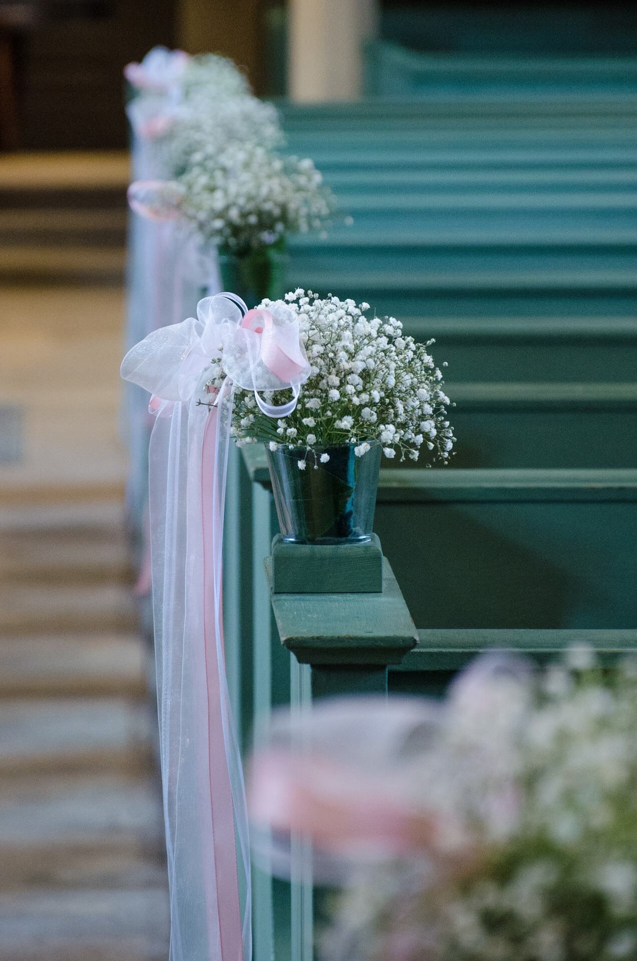 Zarte Blumensträuße an Kirchenbänken