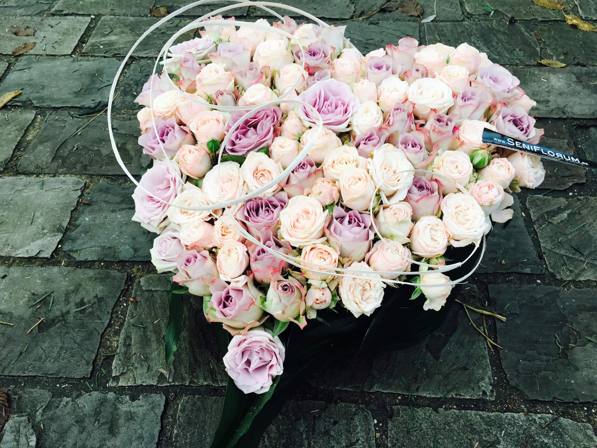 Trauergesteck in Herzform mit pastellfarbenen Rosen